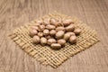 Pinto Bean legume. Grains on square cutout of jute. Wooden table