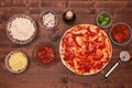 Phases of making a pizza - spreading tomato sauce on the dough