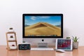 IMac computer, keyboard, magic mouse, iPhone X, iPad mini, plant vase and cactus pots on wooden table Royalty Free Stock Photo