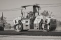 Zoom Back View Black and White Worker and Road Roller on Asphalt Road