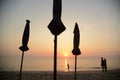 Silhouettes of an unidentified family tourists while walking on Cha-am beach in the morning as the sun rises over the sea.