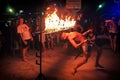 Phi Phi Island, Thailand, November 13, 2017: A merry youth people limbos under a bar of fire. Crowd partying in Phi Phi