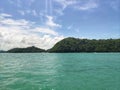 Phi Phi island, Phuket, Thailand green lush tropical island in a blue and turquoise sea with islands in the background and clouds