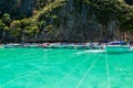 Speed boats docking on anchors near cliff in Maya Bay
