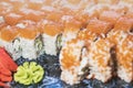 Philadelphia green sushi rolls made from fresh salmon, cream cheese, cucumber, avocado. Served with Ginger and Wasabi on black Royalty Free Stock Photo