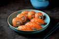 Philadelphia homemade sushi rolls in a blue plate on a black background.