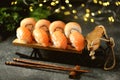 Philadelphia homemade sushi rolls and nigiri sushi with wild salmon on decorative sleigh, christmas background.