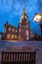 Philadelphia, PA--Feb 4, 2020; lights in the windows and clock tower of Independence Hall illuminate the grounds with wooden bench Royalty Free Stock Photo