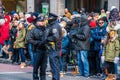 Two Philadelphia Police officers stand in front of crowd of spectators on Broad Street during the New Years Day Mummers Parade