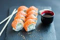 Philadelphia roll classic on a dark stone background. Salmon, Philadelphia cheese, cucumber, avocado. Japanese sushi. Royalty Free Stock Photo