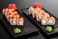 Maki Sushi set on dark pattern background. Sushi Set nigiri, rolls and sashimi served in black square plate Royalty Free Stock Photo