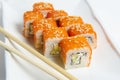 Philadelphia rolls on a white plate with chopsticks. with salmon