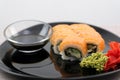 Philadelphia sushi Black plate, black chopsticks, soy sauce, white background, close-up of sushi on a black background Royalty Free Stock Photo