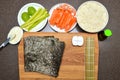 philadelphia sushi maki and ingredients, on a wooden cutting board, top view, copy space on nori sheet Royalty Free Stock Photo