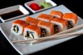 Traditional Japanese cuisine. Philadelphia sushi roll made of fresh salmon, avocado and cream cheese with black rice Royalty Free Stock Photo