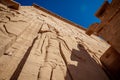Philae Temple facade with giant rock carved statue of Isis Goddess and hieroglyphs Royalty Free Stock Photo