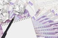 100 Philippine piso bills and balls of crumpled paper with blank notepad. Bad ideas or less of inspiration concept. Searching Royalty Free Stock Photo