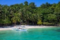 Philippine wooden boat and white beach on sunny day. Tropical island paradise photo. Palm tree jungle forest