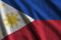 Philippines flag with big folds waving close up under the studio light indoors. The official symbols and colors in