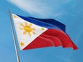 Philippines flag on a pole waving. Philippines realistic flag waving against clean blue sky. Royalty Free Stock Photo