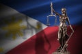 Philippines flag with statue of lady justice and judicial scales in dark room. Concept of judgement and punishment