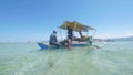 Philippines, Manjuyod, 18-05-2019: Girl buys coconut from trading boat bangka.