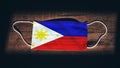 Philippines National Flag at medical, surgical, protection mask on black wooden background. Coronavirus CovidÃ¢â¬â19, Prevent