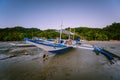 The Philippines`s Banca boat. Traditional fishing boat on beach during low tide in evening light. El Nido,Palawan Royalty Free Stock Photo