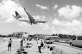 Philipsburg, Sint Maarten - February 13, 2016: airplane land over people on maho beach. Plane low fly on cloudy blue sky Royalty Free Stock Photo