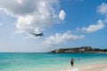 Philipsburg, Sint Maarten - February 13, 2016: plane land over maho beach. Jet flight low fly in cloudy sky. Airplane on blue sea. Royalty Free Stock Photo