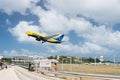Philipsburg, Sint Maarten - February 13, 2016: plane low fly over maho beach. Jet flight land on cloudy blue sky. Airplane in sunn Royalty Free Stock Photo
