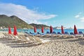 Philipsburg, St. Martin - 1/23/18: Beach umbrellas and lounge chairs along the beach and the Carnival Conquest cruise ship docked Royalty Free Stock Photo