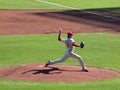 Philles Cole Hamels steps forward to throw pitch with arm in the air and shadow casting on the ground