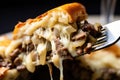 a philly cheesesteak bite with beef, cheese, and onions on a fork