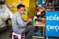 Phnom Penh, Cambodia - December 7, 2018. A street cobbler works on shoes