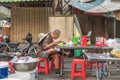 Phnom Penh, Cambodia: a lone Asian traveler eats at the table in a street restaurant.