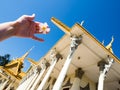 Tourist holding frangipani flower against the backdrop of the Throne Hall inside the