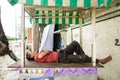 Image of a tired man sleeping in the street. Homeless, poor guy.