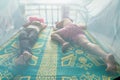 Image of a Khmer rural people in the countryside inside of a mosquito net. Resting, sleeping.