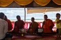 Image of people in buddhist temple paying respect to monks. Religious celebration. People serving rice to monks. Royalty Free Stock Photo