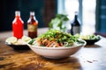 pho bowl with sriracha and hoisin sauce bottles behind it Royalty Free Stock Photo