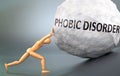 Phobic disorder and painful human condition, pictured as a wooden human figure pushing heavy weight to show how hard it can be to Royalty Free Stock Photo