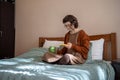 Teen girl reading messages scrolling social media in smartphone drinking tea in bed. Phone addiction Royalty Free Stock Photo