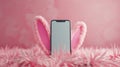 Phone with bunny ears on fluffy pink carpet. Great for Easter promotions Royalty Free Stock Photo