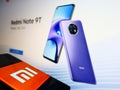 Phone with business logo of Chinese smartphone manufacturer Xiaomi Corporation on display in front of company website.