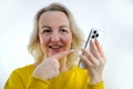 phone call advertisement sale woman pointing finger at white smartphone orange clothes smile blonde middle age