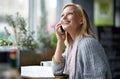 Phone call, coffee shop and woman with smile for conversation, social networking and talking. Restaurant, cafe and happy Royalty Free Stock Photo