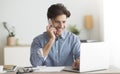 Happy Entrepreneur Talking On Cellphone Sitting At Laptop In Office Royalty Free Stock Photo