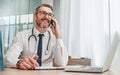 Phone call, laptop and male doctor doing a telehealth consultation in his office in the hospital. Technology Royalty Free Stock Photo