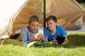 Phone, camping and boys in tent in nature streaming online movie, show or film on mobile app. Travel, technology and Royalty Free Stock Photo